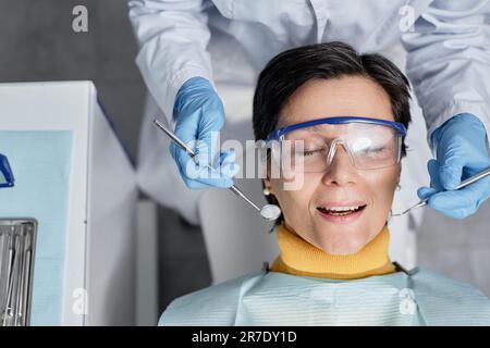 Draufsicht der reifen Frau im zahnärztlichen Stuhl während der Zahnuntersuchung, Kopierraum Stockfoto