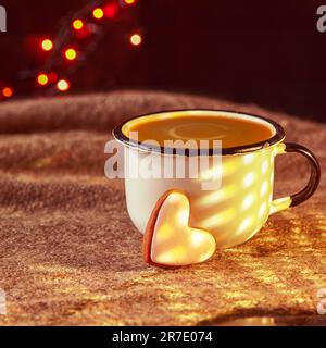 Latte Tasse und herzförmiges Lebkuchen. Lebkuchen und heißes Getränk. Seichter dof. Alte Tasse Kaffee mit herzförmigen Keksen auf Leinenstruktur. Stockfoto