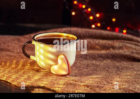 Herzförmige Tasse Kaffee und Lebkuchen. Seichte dof. Alte Tasse Kaffee mit herzförmigen Keksen auf Leinenstruktur. Stockfoto