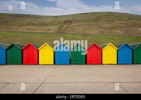 Hell bemalte Strandhütten entlang des Cleveland Way in Whitby, Teil von North Yorkshire und Cleveland Heritage Coast. UK. Stockfoto