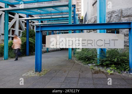 Bielefeld, Deutschland. 15. Juni 2023. Ein großes Schild hängt am Eingang zum Regionalgericht Bielefeld. Dort beginnt der Prozess eines angeblichen Giftmordes. Die beiden Angeklagten sollen eine außereheliche Beziehung gehabt haben. Gemeinsam sollen die Frau aus Bielefeld (50) und ihr Freund aus Hamburg (45) den Plan umgesetzt haben, den Ehemann am 30. April 2022 mit einem Gift zu töten. Laut der Anklage legte die Frau eine giftige Mischung in ein Glas Wasser neben das Bett des Mannes. Kredit: Friso Gentsch/dpa/Alamy Live News Stockfoto