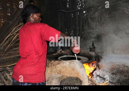 Äthiopische Frau, die injera kocht. Injera ist ein traditionelles Gericht aus Teff-Geschmack, ein Nationalgericht in Äthiopien. Holz ist die Energiequelle. Stockfoto
