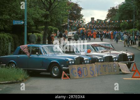 Gott schütze die Königin. Queen Elizabeth II. Silberjubiläumsfeier 1977. Drei Rolls Royces in Blau, Weiß, Grau und Rot, Block der Straße, ein Schild auf Pappkartons steht "Gott rette die Königin". Hampstead, Nord-London, England, ca. Juni 1977. 1970S GB HOMER SYKES Stockfoto