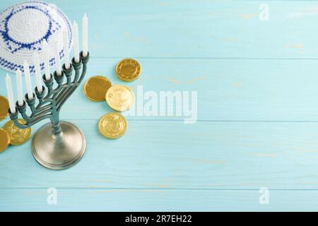 Frohes Chanukka. Chanukka altes Menorah vor dem Hintergrund der israelischen Flagge mit Sonnenlicht oder Bokeh auf weißem Holzhintergrund. Religionsbild der juden Stockfoto