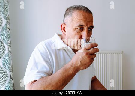 Porträt eines Mannes mittleren Alters mit Glas in der Hand Stockfoto