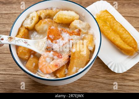 Blick auf Meeresfrüchte-Haferbrei mit Krabben und Garnelen, weißen Muscheln und frittierten Teigstiften in horizontaler Zusammensetzung Stockfoto
