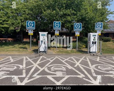 Westerham, Kent, England, Großbritannien. 2023. Ladestationen für Elektrofahrzeugbatterien auf einem Parkplatz einer Tankstelle in Kent, Vereinigtes Königreich. Stockfoto