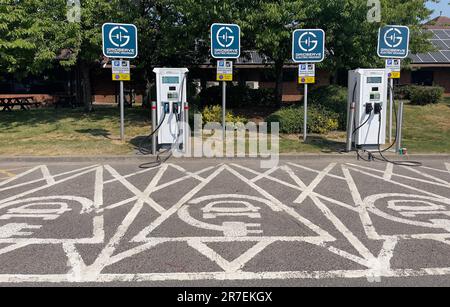 Westerham, Kent, England, Großbritannien. 2023. Ladestationen für Elektrofahrzeugbatterien auf einem Parkplatz einer Tankstelle in Kent, Vereinigtes Königreich. Stockfoto