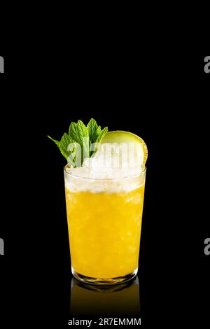 Ein Glas kalten Mai Tai-Cocktail mit Melonenscheiben isoliert auf schwarzem Hintergrund. Fruchtiger gefrorener alkoholischer Cocktail. Stockfoto