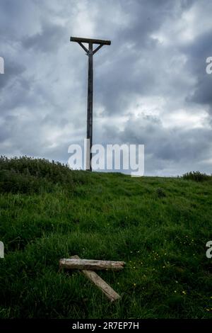 Ein Blick auf den Coombe Gibbet auf Gallows Down, Berkshire, vor einem wolkigen Himmel mit verworfenen Holzplanken im Vordergrund. Hochformat Stockfoto