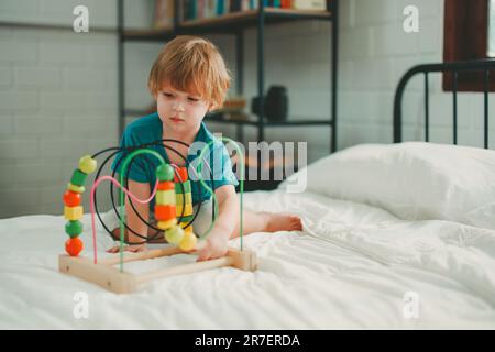 Neben lustigen Lernspielzeugen und Bausteinen fördern sie die Gehirnentwicklung, verbessern die Koordination der Hand und der Augen, fördern die Feinmotorik und fördern die Konzentration Stockfoto