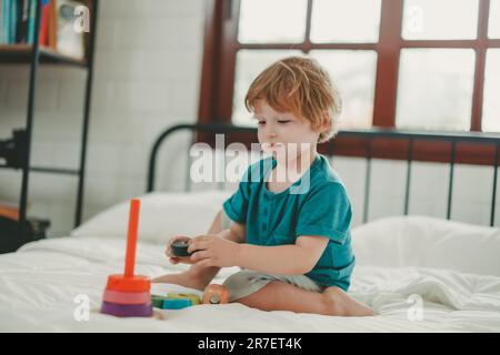 Neben lustigen Lernspielzeugen und Bausteinen fördern sie die Gehirnentwicklung, verbessern die Koordination der Hand und der Augen, fördern die Feinmotorik und fördern die Konzentration Stockfoto