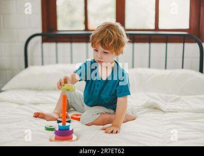 Neben lustigen Lernspielzeugen und Bausteinen fördern sie die Gehirnentwicklung, verbessern die Koordination der Hand und der Augen, fördern die Feinmotorik und fördern die Konzentration Stockfoto