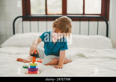 Neben lustigen Lernspielzeugen und Bausteinen fördern sie die Gehirnentwicklung, verbessern die Koordination der Hand und der Augen, fördern die Feinmotorik und fördern die Konzentration Stockfoto