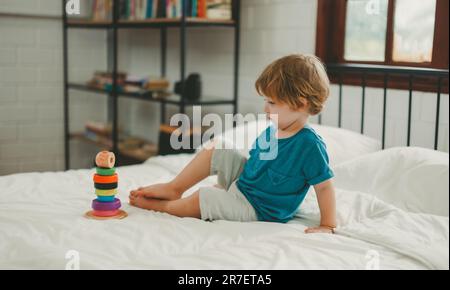 Neben lustigen Lernspielzeugen und Bausteinen fördern sie die Gehirnentwicklung, verbessern die Koordination der Hand und der Augen, fördern die Feinmotorik und fördern die Konzentration Stockfoto