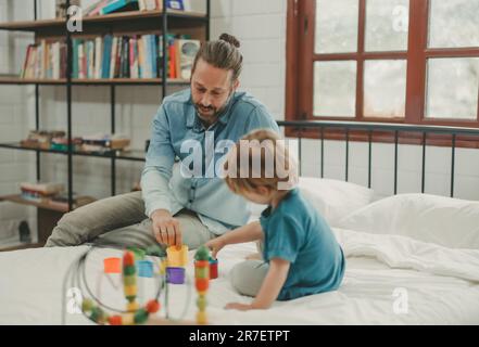 Neben lustigen Lernspielzeugen und Bausteinen fördern sie die Gehirnentwicklung, verbessern die Koordination der Hand und der Augen, fördern die Feinmotorik und fördern die Konzentration Stockfoto