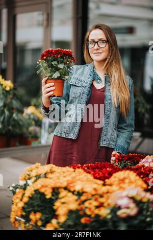 Eine Frau, die Blumen in Töpfen im Blumenladen kauft Stockfoto