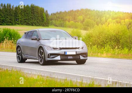 Silbernes Kia EV6-V-Elektroauto mit hoher Geschwindigkeit auf der Autobahn in goldenem Sommersonnenlicht. Stockfoto