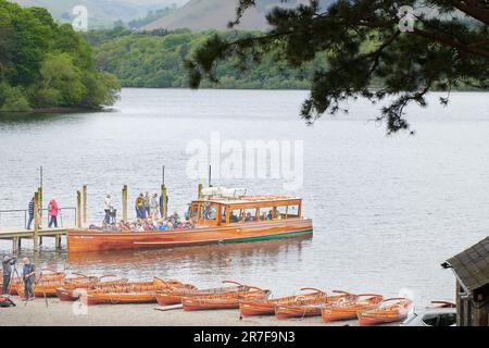 Ein Bootsanleger, der in der Nähe von Ruderbooten am Ufer des Lake Derwent Water, Lake District, Cumbria, England festgemacht ist. Stockfoto