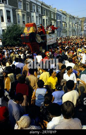 Notting Hill Karneval August Feiertag Montag 1979. Eine bunte Menschenmenge von Karnevalsbesuchern genießt die Musik, eine karibische Band spielt auf einem „Float“-LKW, der langsam durch die Menschenmassen von Partygängern fährt. Notting Hill, London, England, 27. August 1979. 1970S GB HOMER SYKES Stockfoto