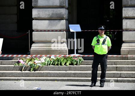 Nottingham, Großbritannien. 14. Juni 2023. Nottingham greift an: Ein Polizist wacht über die Blumenwürfel, die heute auf den Stufen des Council House Building im Stadtzentrum hinterlassen wurden, nach den Angriffen der vergangenen Tage, bei denen 3 Menschen starben und 3 verletzt wurden. Nottingham City, Nottingham, Vereinigtes Königreich, 14. Juni 2023 (Foto von Lisa Harding/News Images) in Nottingham, Vereinigtes Königreich, 6/14/2023. (Foto: Lisa Harding/News Images/Sipa USA) Guthaben: SIPA USA/Alamy Live News Stockfoto