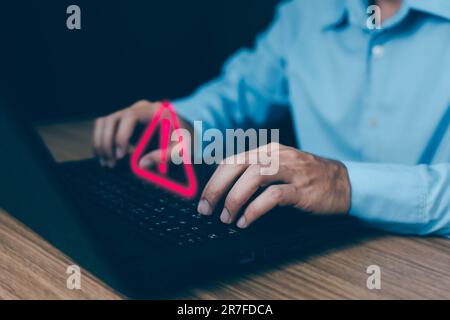 Geschäftsmann, der einen Computer-Laptop mit Warndreieck benutzt, singt für Fehlerbenachrichtigung und Wartungskonzept. Stockfoto