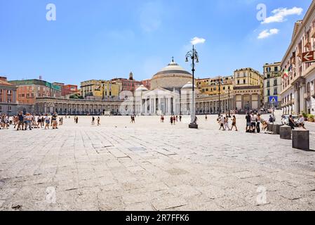 Neapel, Italien. Blick auf die Piazza Plebiscito an einem sonnigen Tag mit einigen Touristen, die über den Platz laufen. Im Hintergrund die königliche päpstliche Basilika Stockfoto