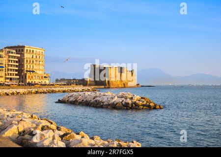 Neapel, Italien. Blick von der Via Partenope auf das Castel dell'Ovo. Im Vordergrund ist das Wellenbrecher-Felsen. 2023-01-03. Stockfoto