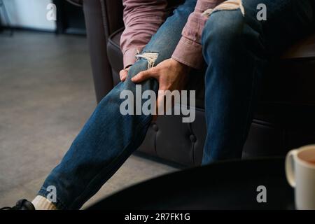 Erwachsene Person im Raum mit Knieschmerzen Stockfoto