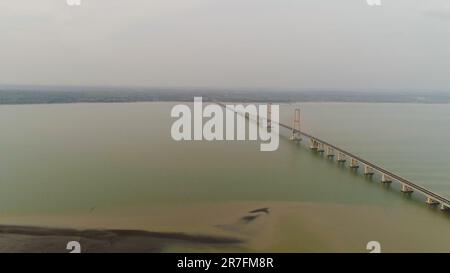 Hängebrücke über madura Meerenge mit Autobahn und Auto, Surabaya. luftaufnahme Brücke Suramadu verbinden die Inseln Java, Madura. Höga kusten Brücke mit Autobahn. Java, Indonesien Stockfoto