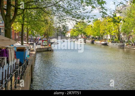 Niederlande. Sonniger Sommertag auf einem Kanal im Zentrum von Amsterdam. Große Lastkähne sind vertäut Stockfoto