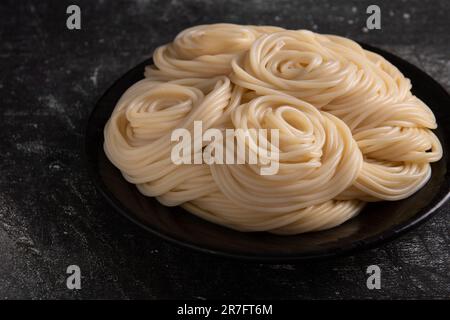 Foto der Pasta auf einem dunklen Teller Stockfoto