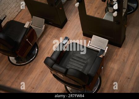 Komfortable Stühle in einem Friseursalon mit minimalistischer Innenausstattung Stockfoto
