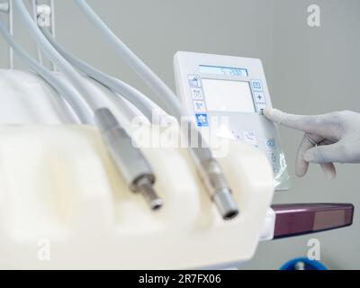 Junge weibliche Zahnärztin mit einem Latexhandschuh zur Vorbereitung von Materialien vor der Operation Stockfoto