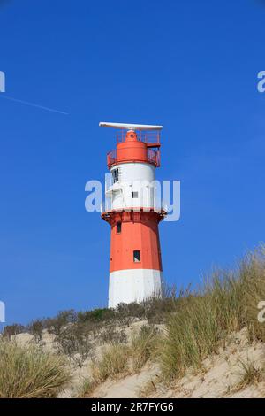 Der elektrische Leuchtturm auf der Insel Borkum steht hinter einer Düne Stockfoto