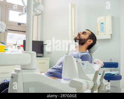 Junger Patient auf einem Zahnarztstuhl in der Zahnklinik und wartet auf den Zahnarzt Stockfoto