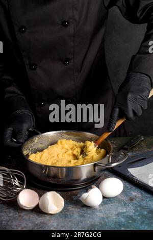 Herstellung von Vanilleteig für Profiteroles, Eclairs. Der Prozess der Herstellung von Profiterolen Stockfoto
