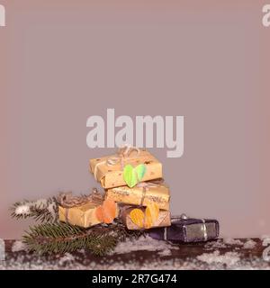 Weihnachten, Neujahrshintergrund. Geschenkboxen, Papierherzen und Tannenzweig. Winterhintergrund mit Geschenken. Kopierbereich. Stockfoto