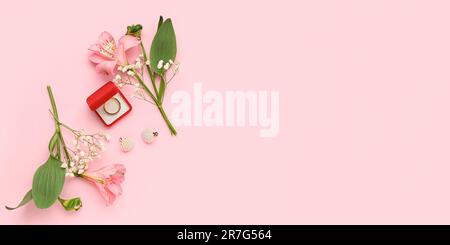 Box mit Verlobungsring, Ohrringen und Blumen auf pinkfarbenem Hintergrund mit Platz für Text Stockfoto