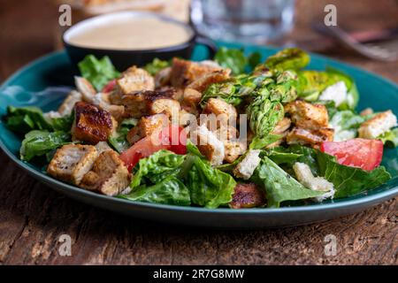 caesar Salat auf einem grünen Teller Stockfoto