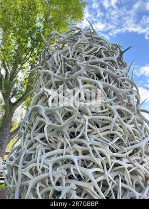 Die Torbogen-Skulptur des Elk Horn Towers befindet sich in Jackson Hole, Wyoming, mit Baum und Himmel im Hintergrund. Waphorngeweih werden mit Schrauben zusammengeschraubt. Stockfoto