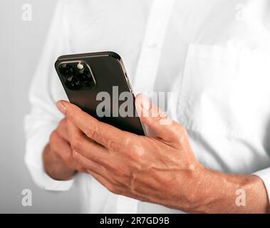 Lodz, Polen, 14 2023. Juni Hand mit Mobiltelefon, schwarzes iPhone 14 Pro Smartphone, Handy in den Händen halten. Stockfoto