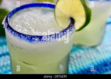 Margarita in einem blau umrandeten Glas, gesalzen mit Limettenscheiben Stockfoto