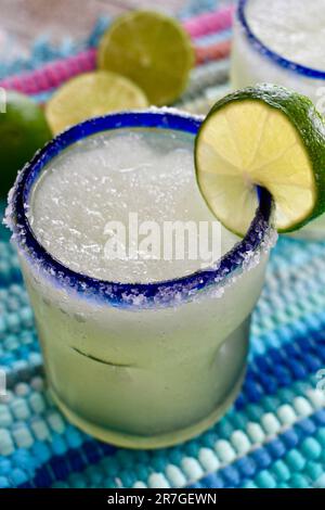 Margarita in einem blau umrandeten Glas, gesalzen mit Limettenscheiben Stockfoto