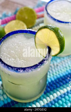 Margarita in einem blau umrandeten Glas, gesalzen mit Limettenscheiben Stockfoto