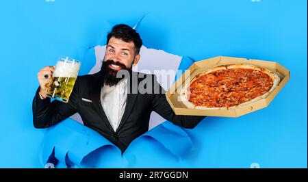 Pizza-Zeit. Glücklicher bärtiger Mann, genießen Sie köstliche Pizza und kaltes Bier. Fastfood. Italienisches Essen. Pizzalieferung. Bärtiger Mann mit leckerer Pizza und einem Becher voll Stockfoto