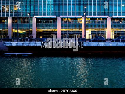 London, Großbritannien - Januar 17 2020: Das leichte Kunstwerk Mi-e-dor-de-tine wird beim Winter Lights Festival in Canary Wharf über dem Middle Dock beleuchtet Stockfoto