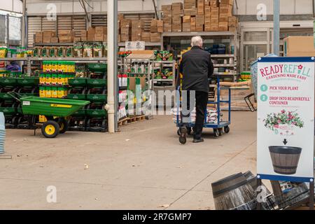 Im Lowe's Garden Center, Wichita, Kansas, USA, schiebt ein erfahrener Weißer einen mit Bodensäcken gefüllten Gartenwagen. Stockfoto