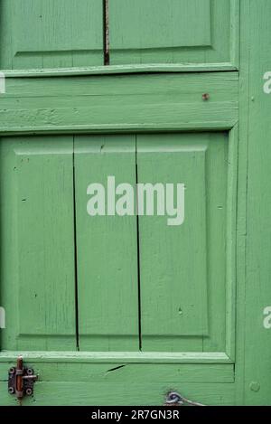 Wunderschöne grüne Holzjalousie an den Fenstern des renovierten alten Gebäudes. Stockfoto