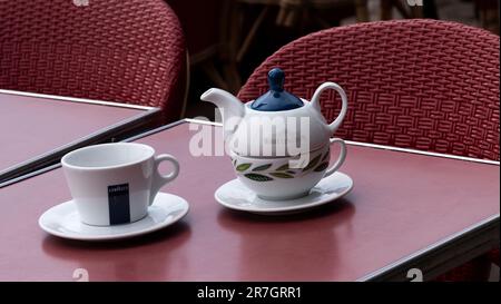 Frankreich, Europa. 2023. Teetasse und Teekanne mit einer Kaffeetasse auf einem Kaffeetisch draußen. Stockfoto